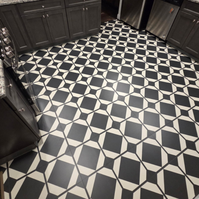 A black and white geometric patterned luxury vinyl tile floor in a kitchen.